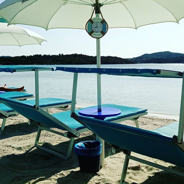lettini azzurri da spiaggia e ombrelloni bianchi