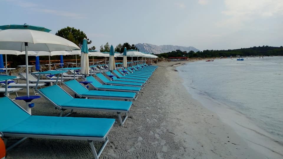 spiaggia con lettini azzurri e mare calmo