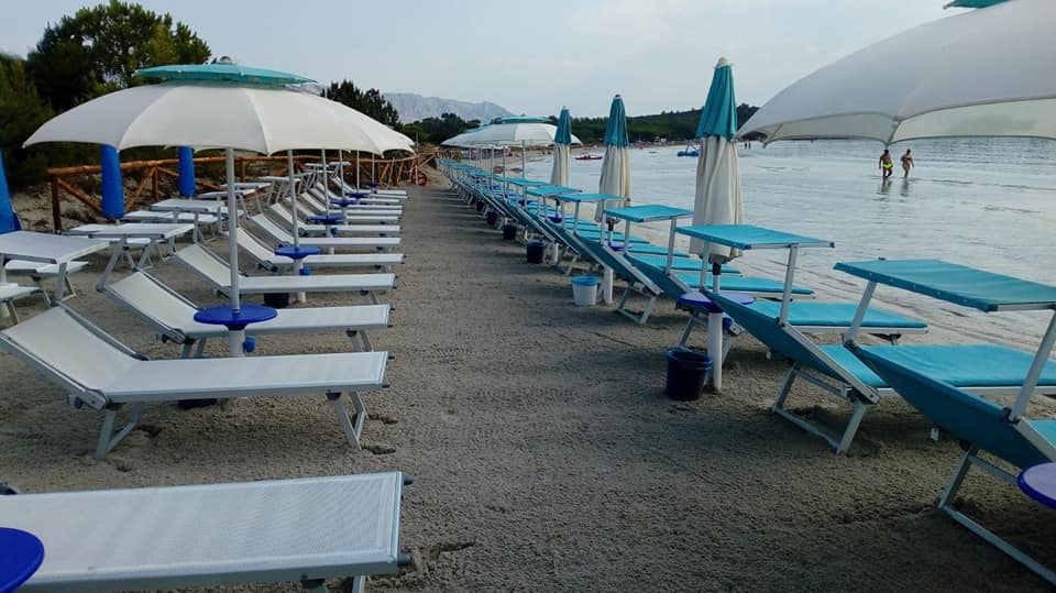 spiaggia con ombrelloni e lettini bianchi e azzurri
