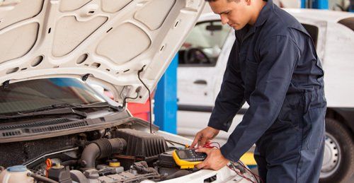 Mechanic testing the current supply in the car