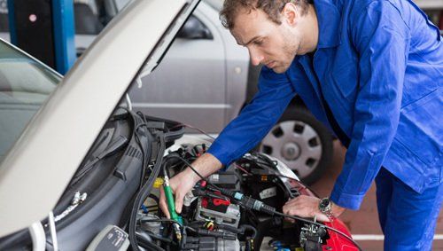 Professional testing the battery of a car