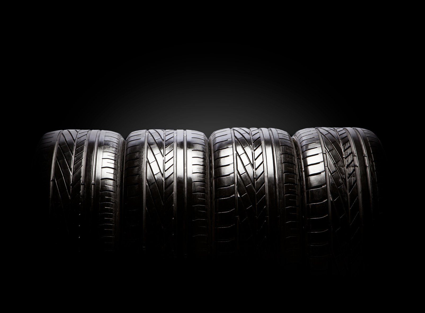 A row of tires stacked on top of each other on a black background.