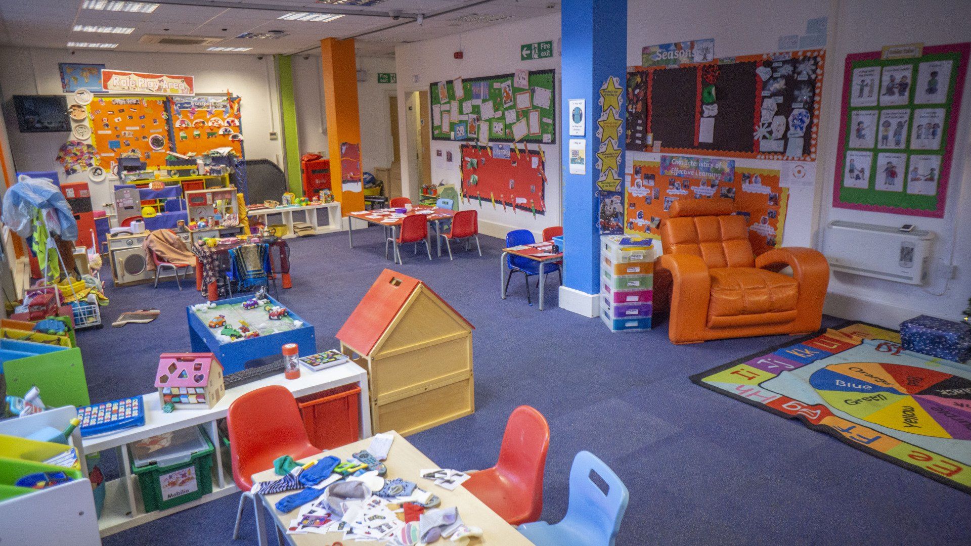 Playroom with toys, tables, chairs, and colorful decorations.