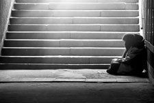 Monochrome photo of homeless woman reading a book