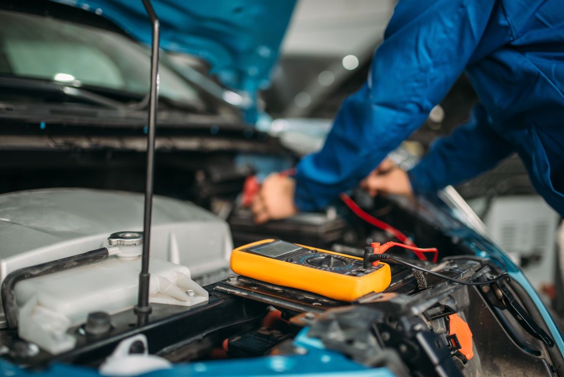 Meccanico controlla l'impianto elettrico di un'auto