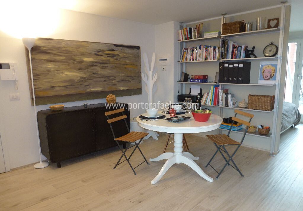 una sala da pranzo con tavolo e sedie e una libreria