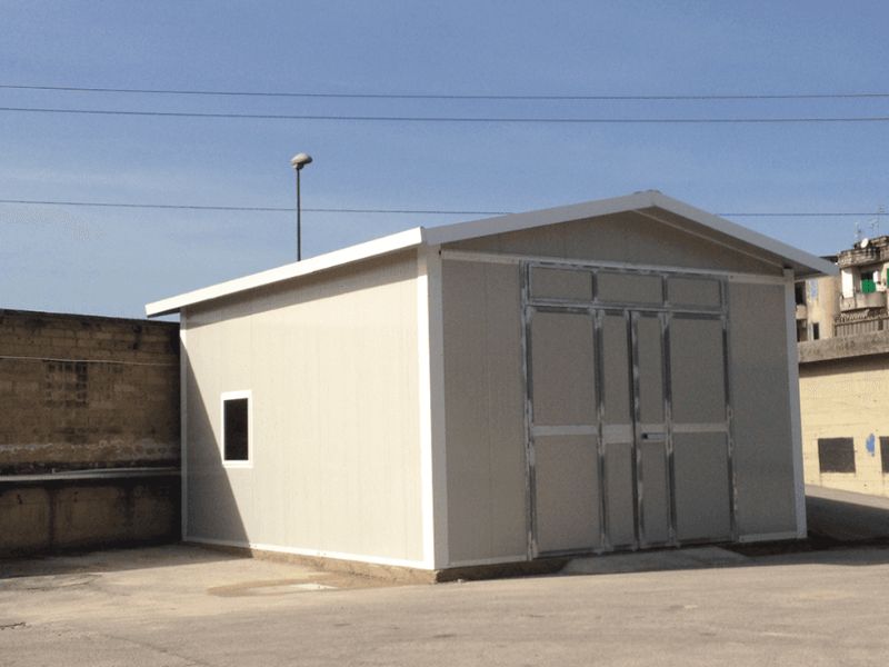 Un piccolo edificio bianco con la porta del garage scorrevole