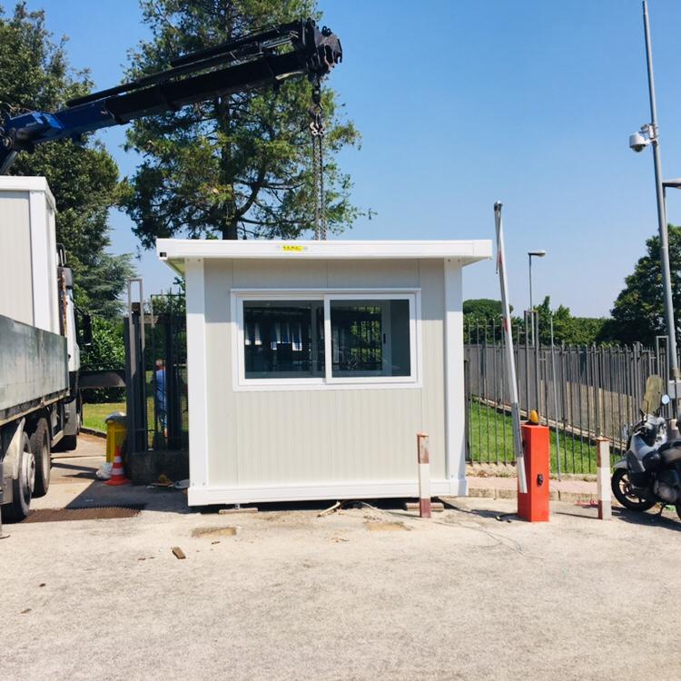 Un piccolo edificio bianco viene sollevato da una gru