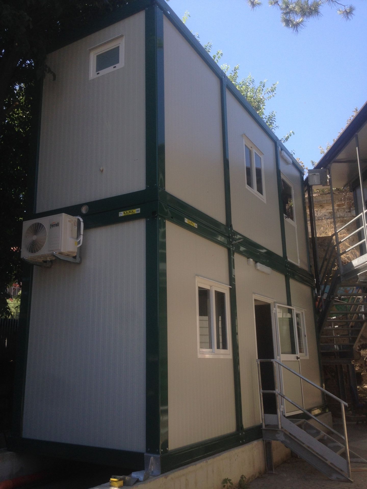 Un edificio bianco e verde con scale che vi conducono