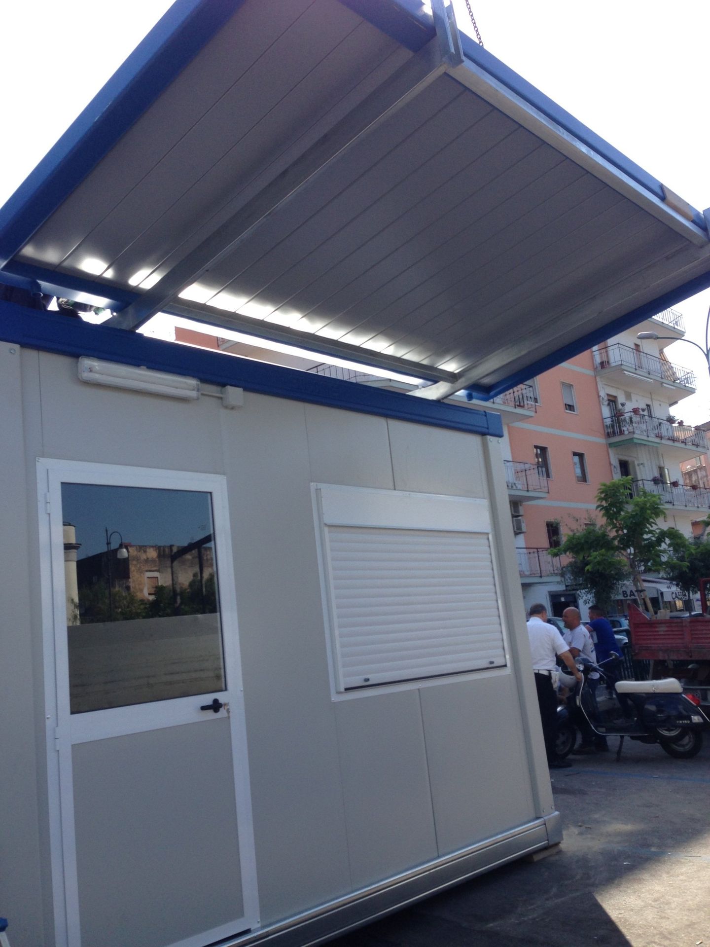 Un edificio bianco con un tetto blu e una porta