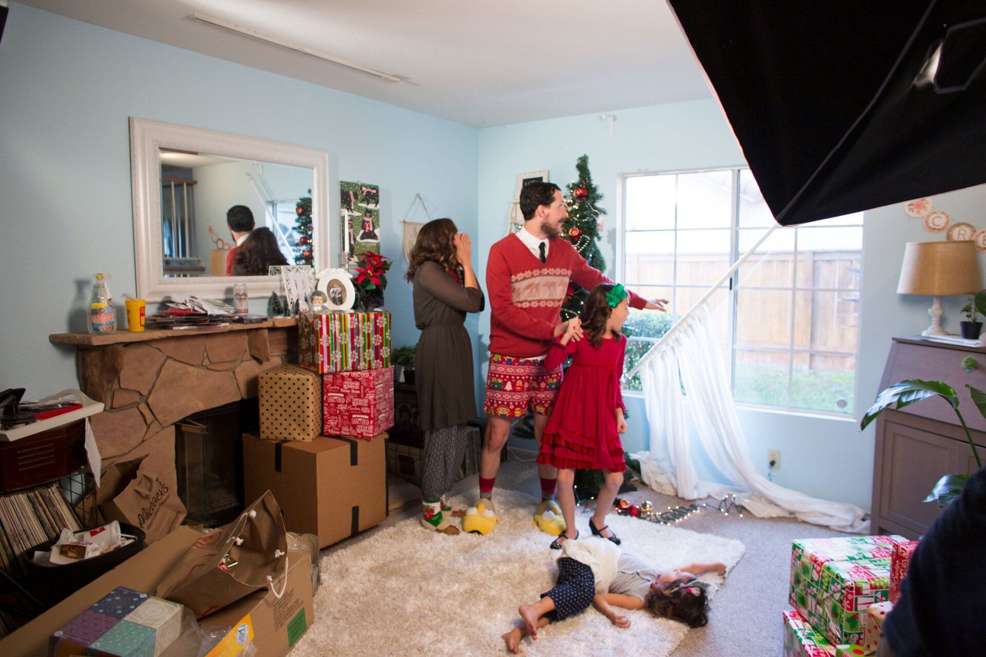 A family is posing for a christmas photo in a living room.