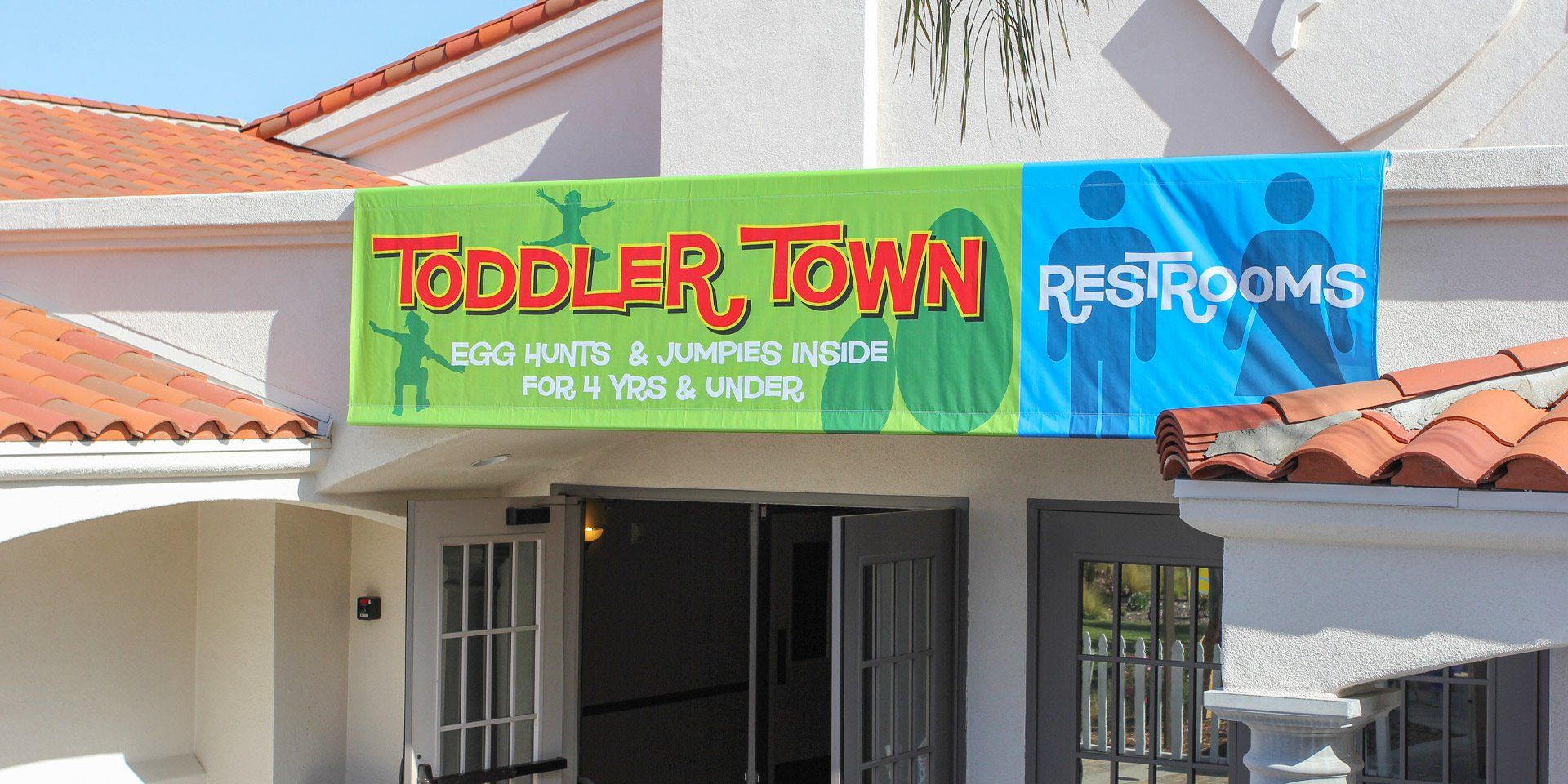 A building with a sign that says toddler town restrooms