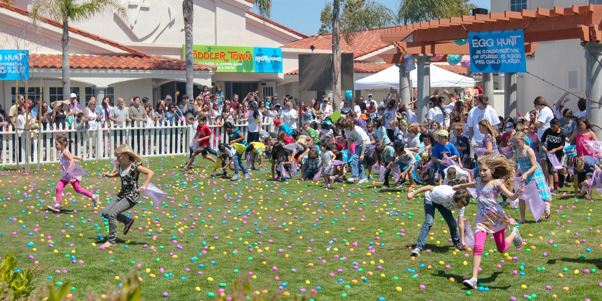 A group of children are running through a field of confetti.