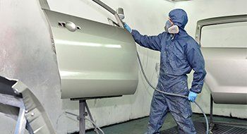 Worker painting car door. Worker painting car door.