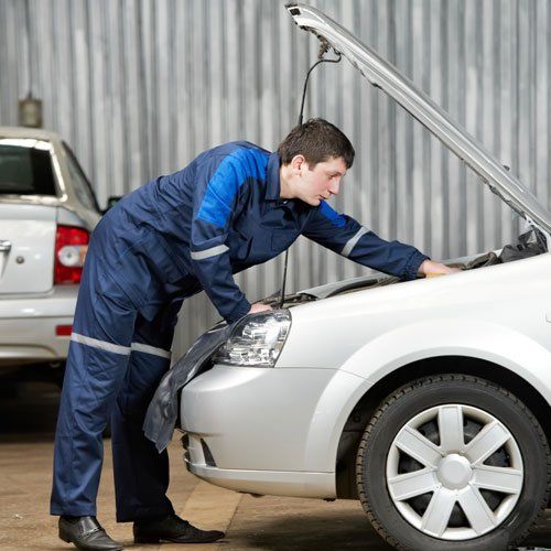 mechanic checking the engine to improve car performance