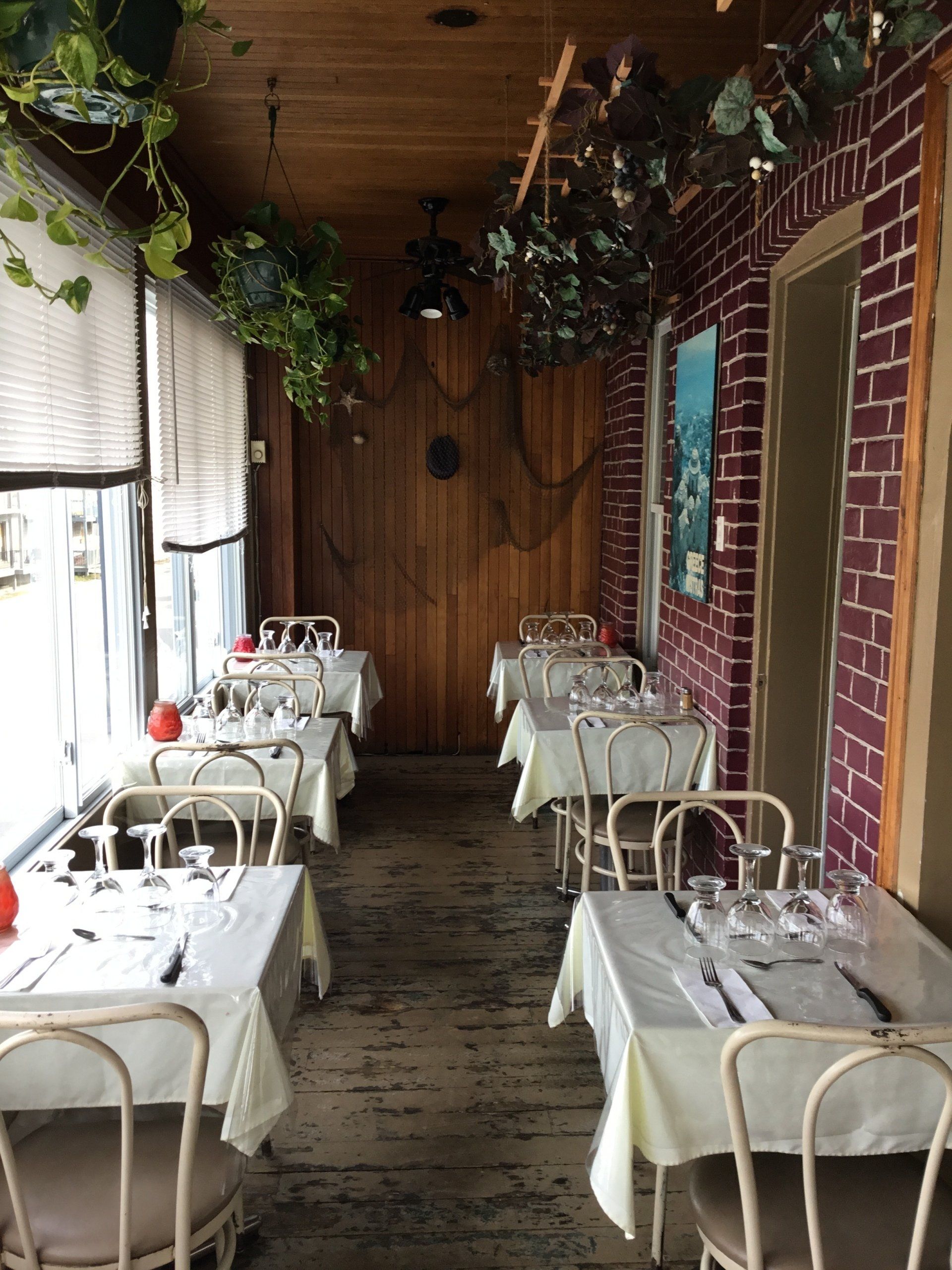 restaurant avec plusieurs tables avec nappes blanches