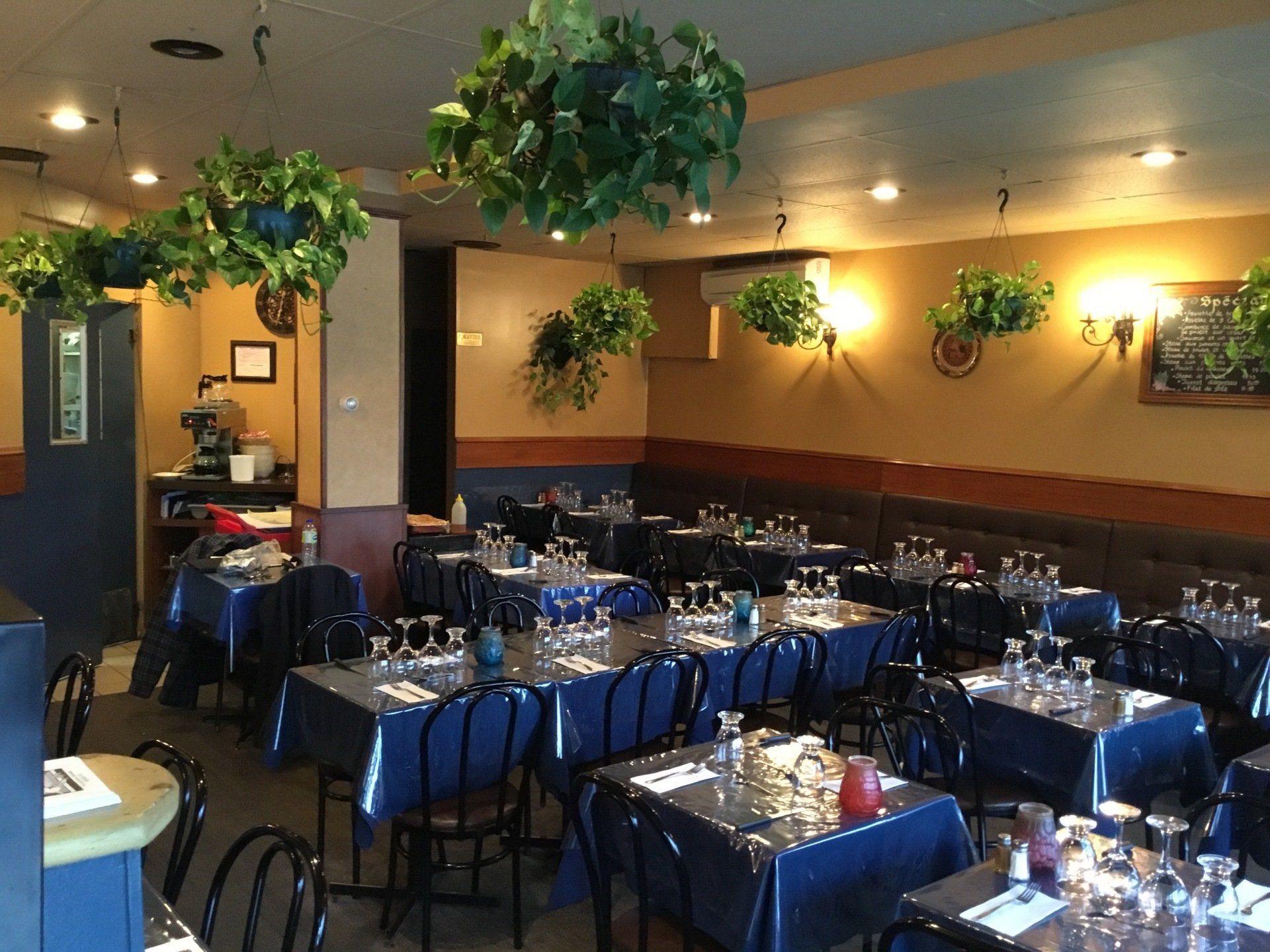 restaurant avec plusieurs tables avec nappe bleue et couverts blancs