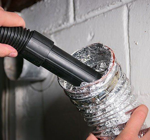 Man Cleaning a Dryer Vent — Cary, IL — Kingsborough Chimney Sweep Inc Man Cleaning a Dryer Vent — Cary, IL — Kingsborough Chimney Sweep Inc