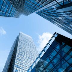 looking up at skyscrapers under blue sky