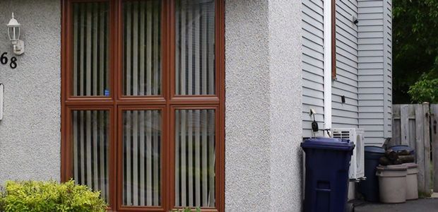 home with white siding and windows with light brown siding