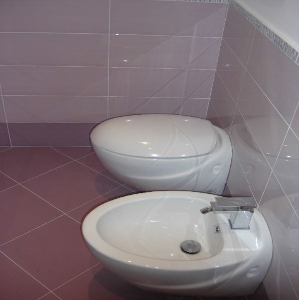 bagno con pavimento e rivestimento viola chiaro