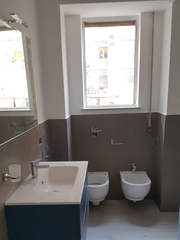 bagno con sanitari sospesi e muro color tortora