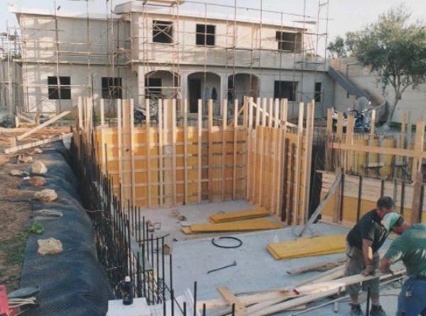 operai di un'impresa edile che costruiscono una piscina