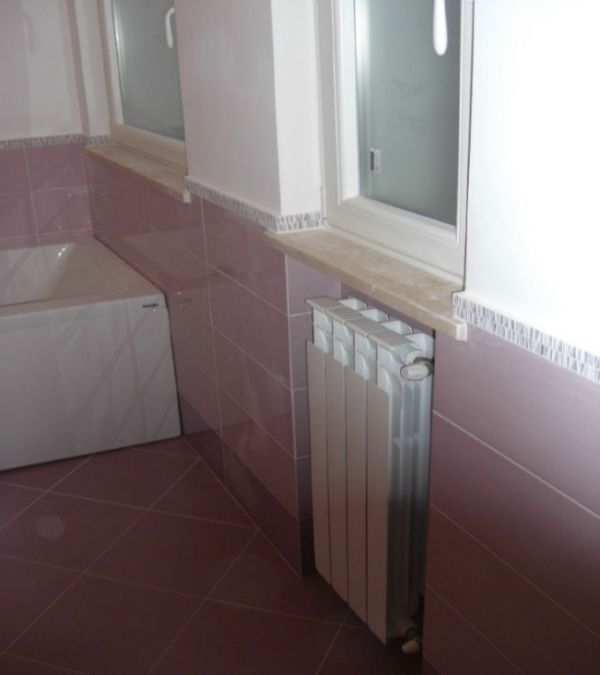 bagno con rivestimenti e pavimentazione lilla