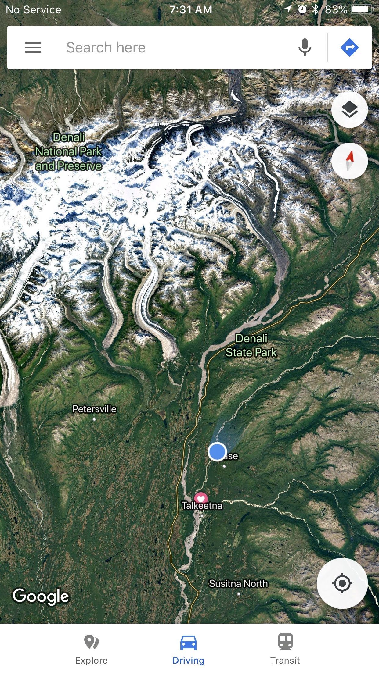 Google Maps view of snowy mountains and valleys with a blue location dot in a green landscape