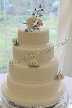 A traditional, circular, four-tier white wedding cake.
