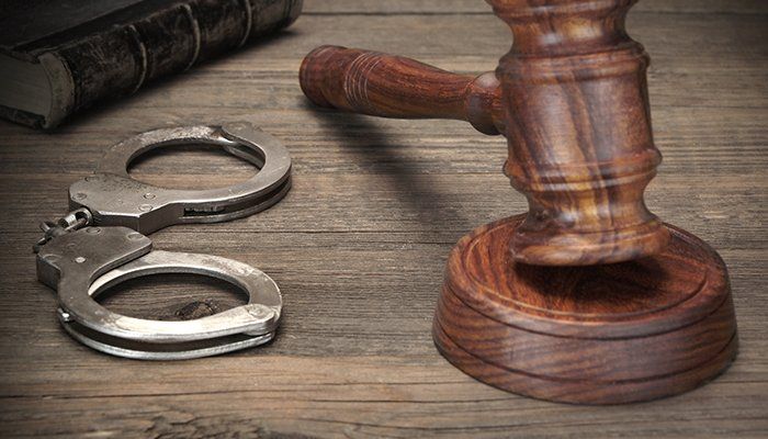 Defendant — Handcuffs, Judge Gavel And Old Law Books On Wooden Table in Kings County, CA