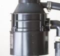 Black garbage disposal unit with connected hoses and a clamp.