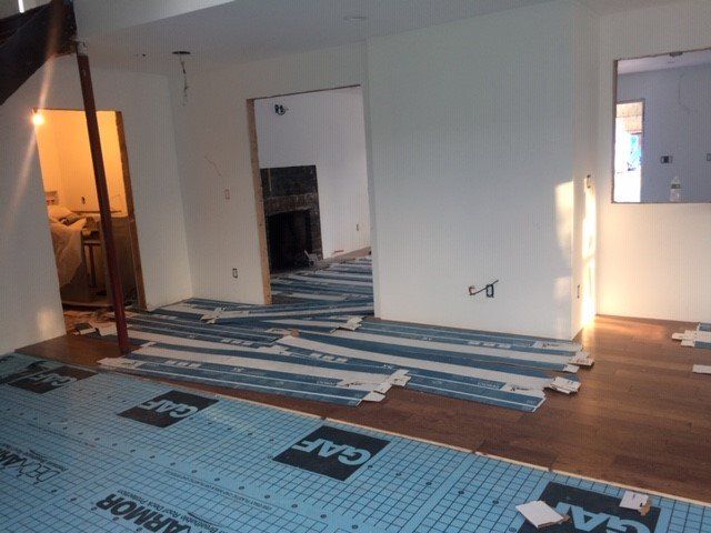 Interior view of a room under renovation, with new flooring being installed.
