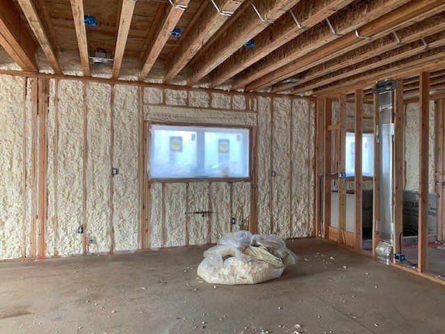 Interior of a building under construction, walls and ceiling framed with wood, sprayed with insulation.