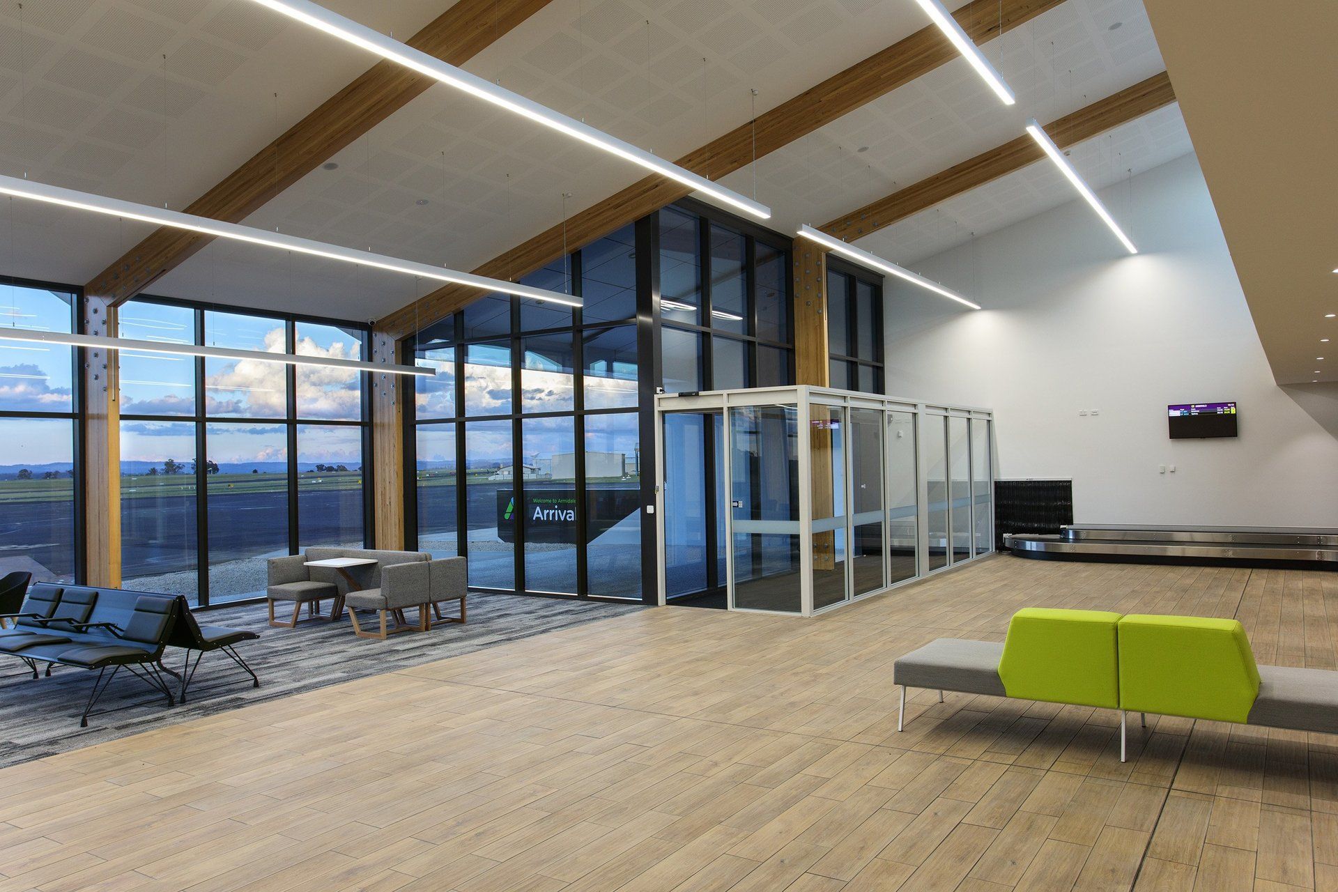 View of armidale airport with a lot of windows and green chairs