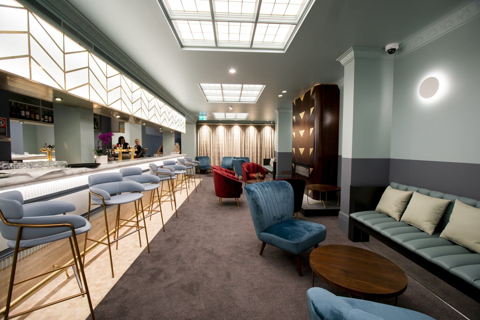 a large room with a couch , chairs , tables and a bar at tattersalls hotel.