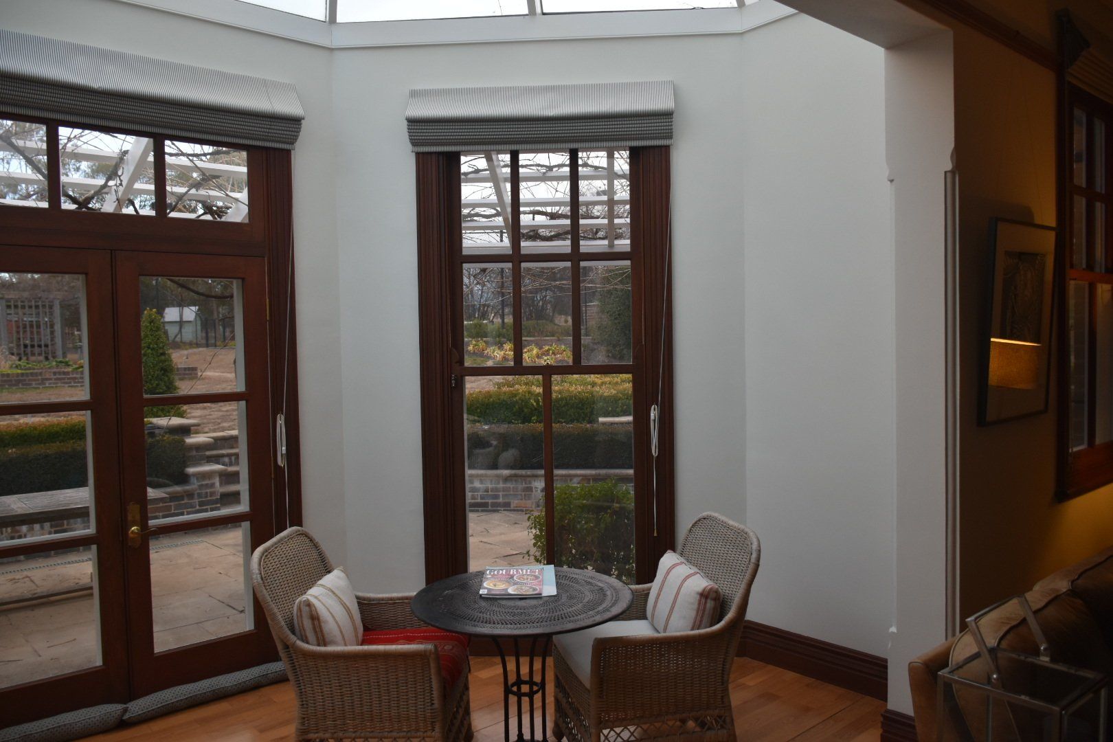 a room with a table and chairs in front of a window .