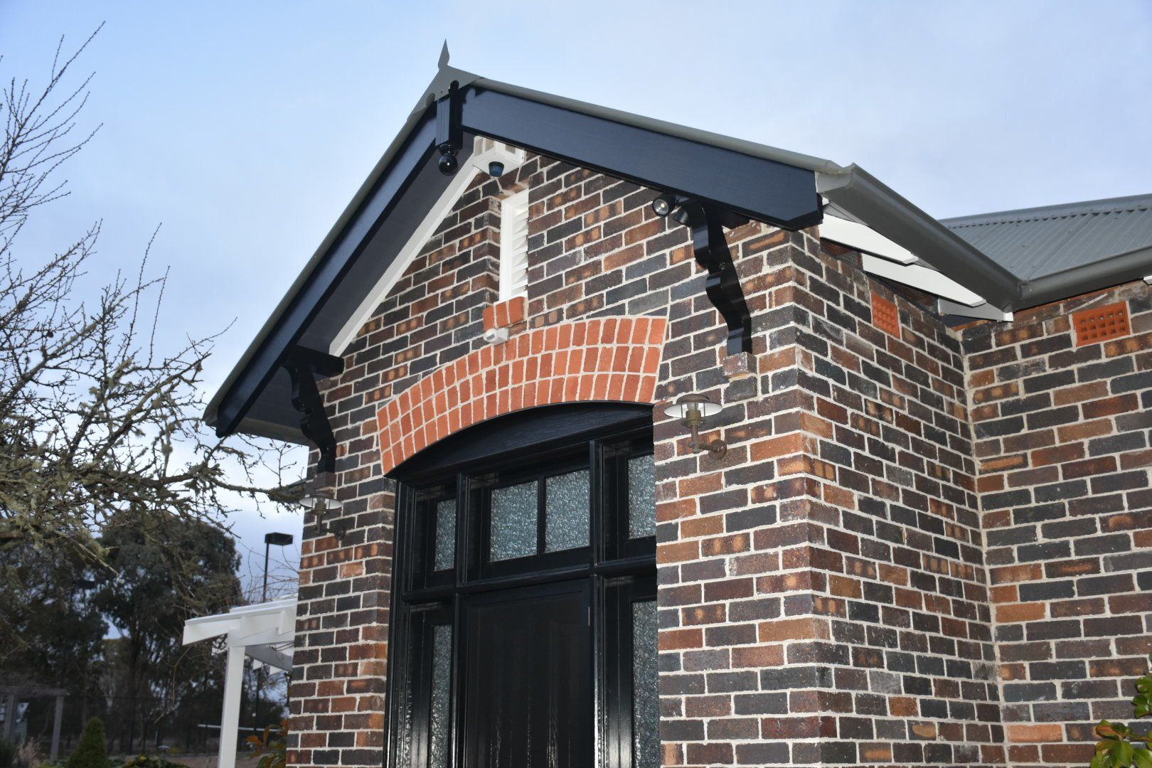a brick building with a black door and black roof trims