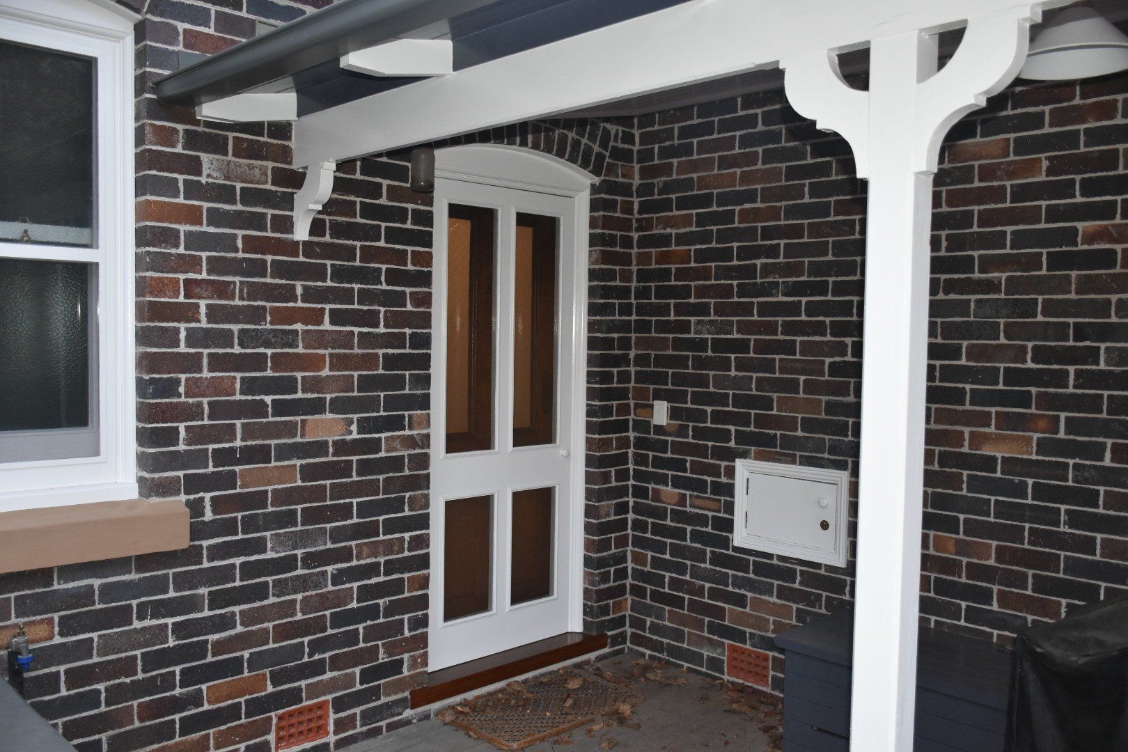 a brick building with a porch and a white door
