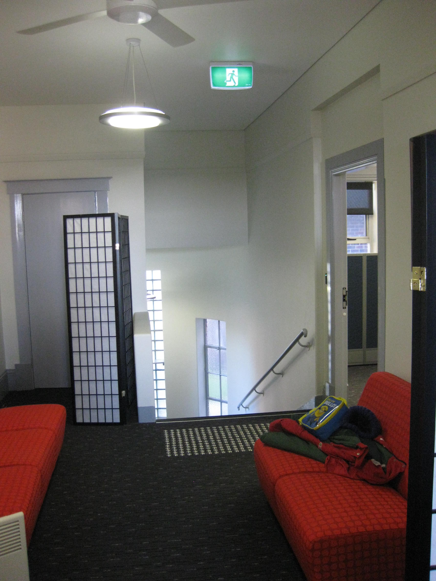 a room with a red couch and a ceiling fan