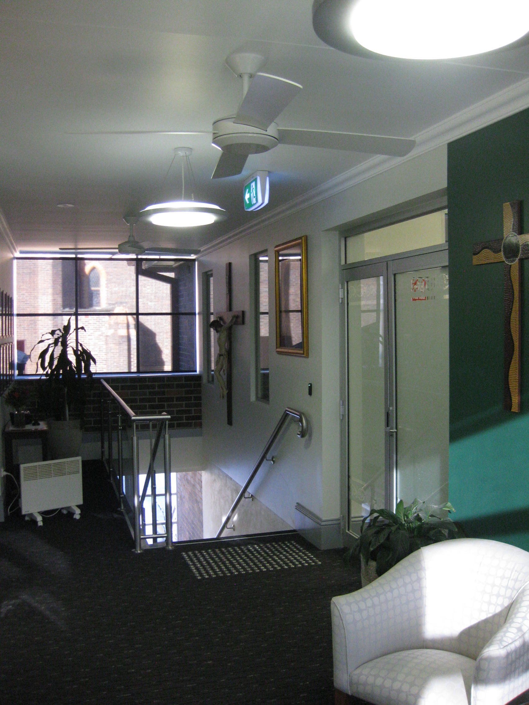 a room with a cross on the wall and a ceiling fan