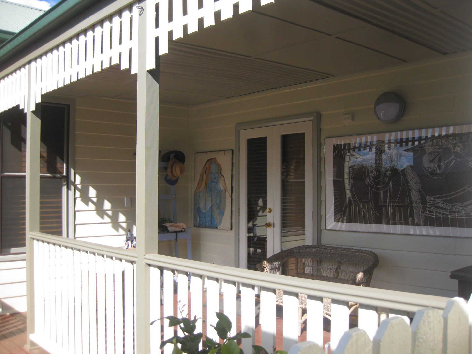 white heritage style house with a porch and a picture on the wall