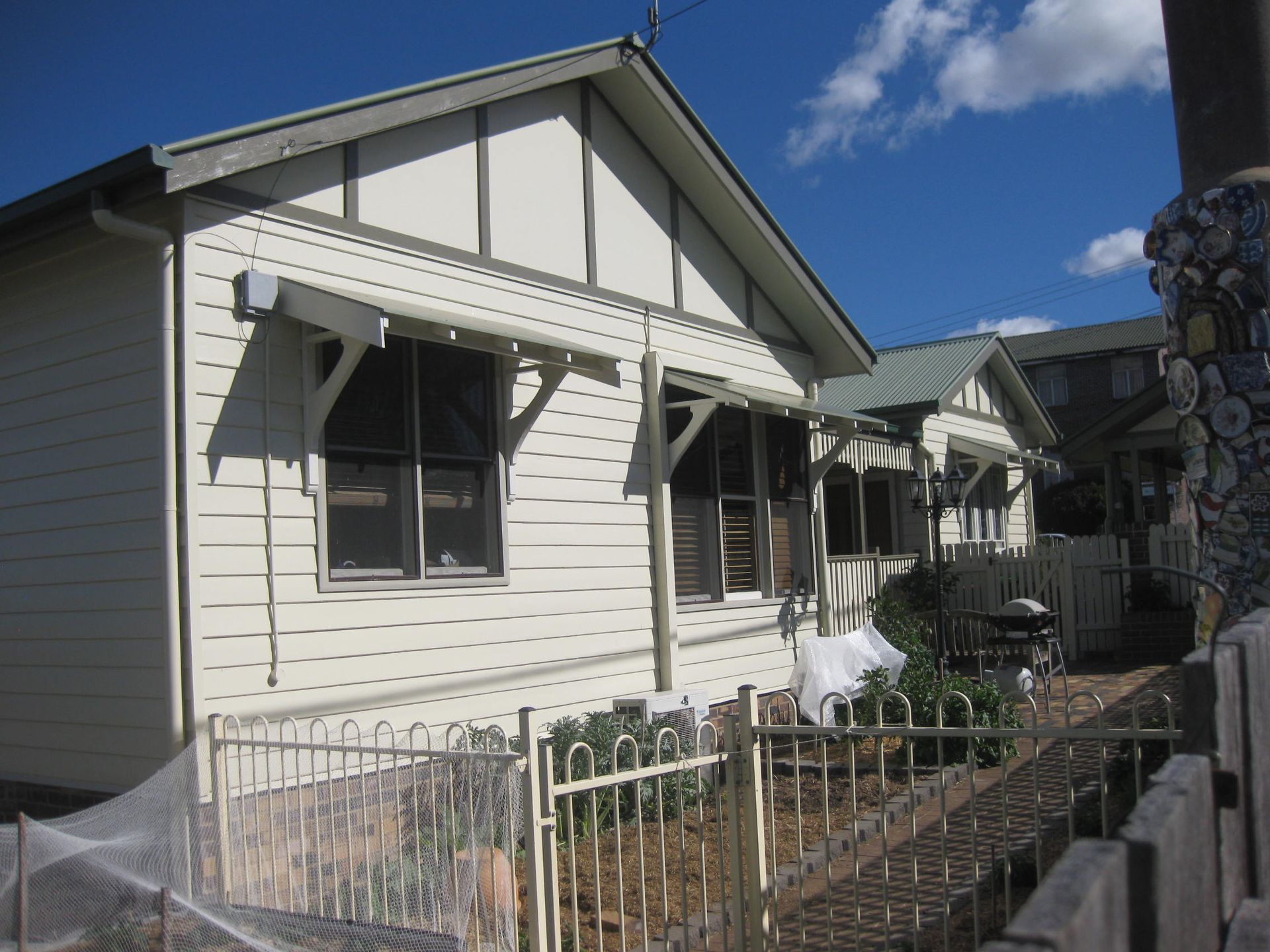 View of white heritage style home from the backyard
