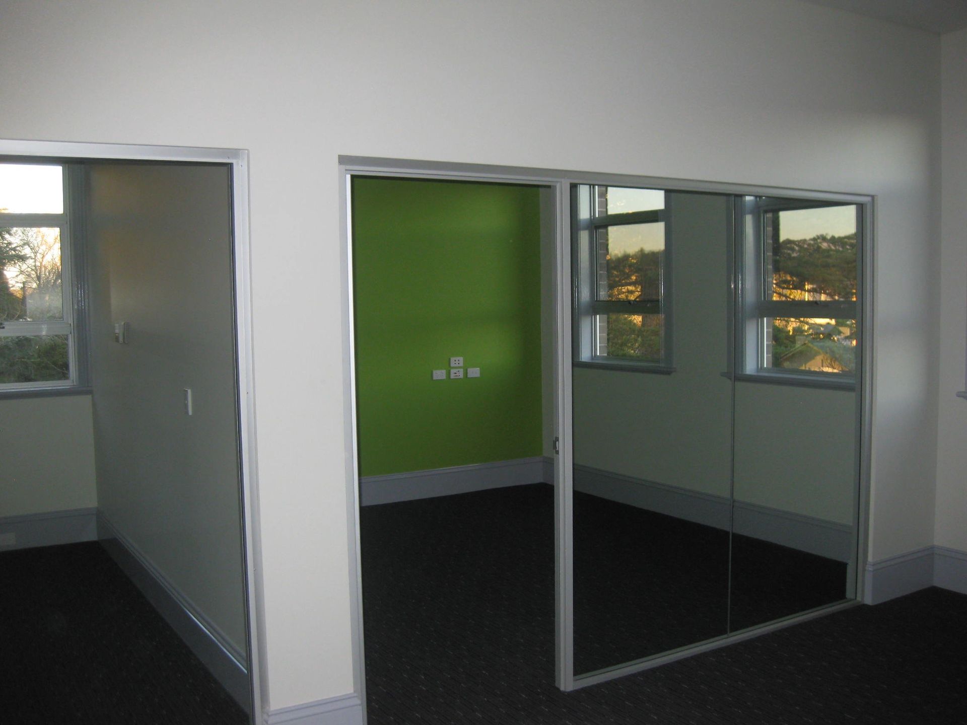 small room with bright green feature wall 