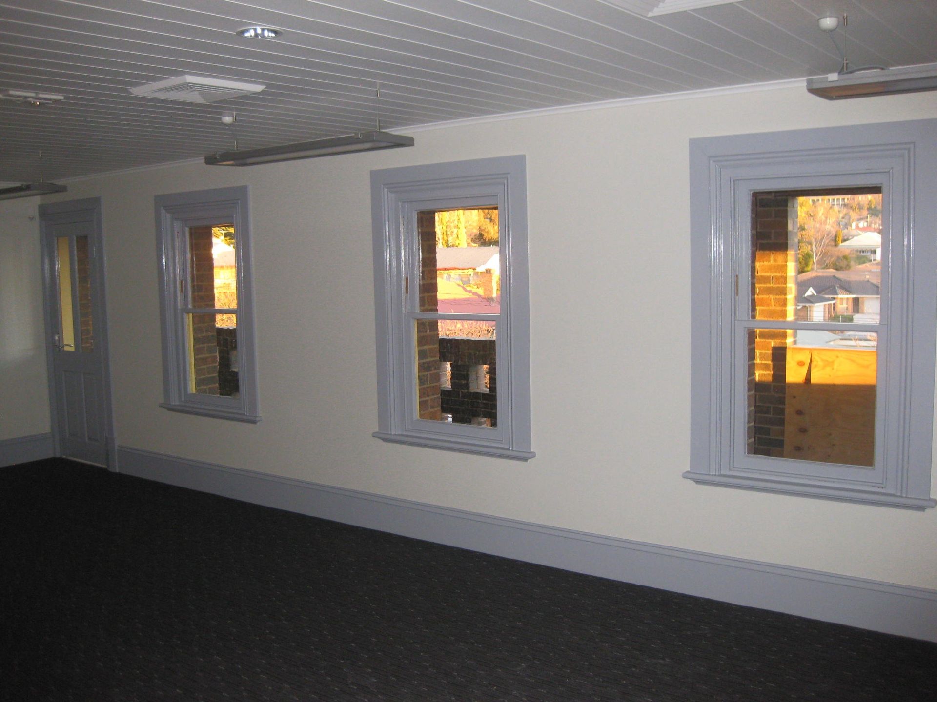 room with 3 long windows and door