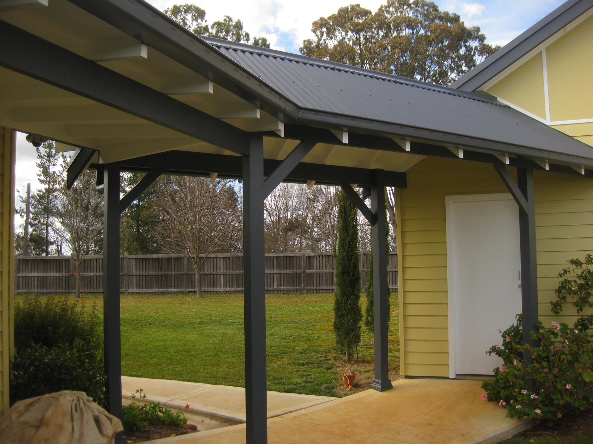 home with a covered walkway leading to a white door and yellow walls