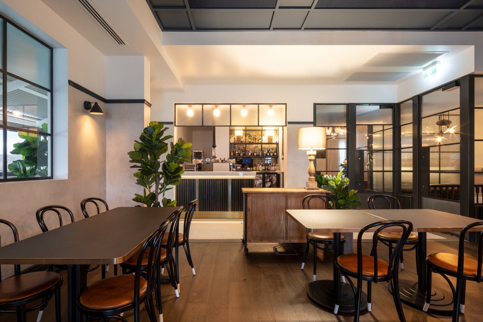 a restaurant with tables and chairs and a bar in the background .