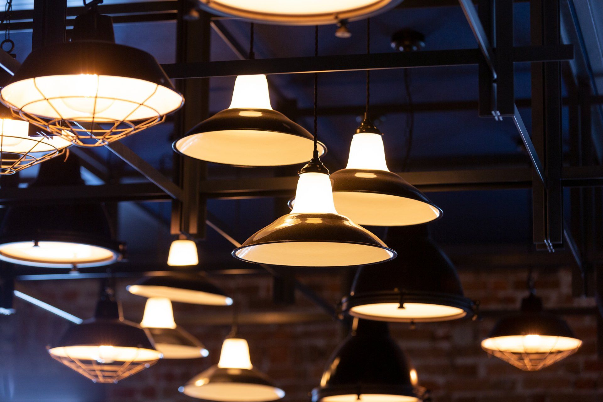 a bunch of pendant lights hanging from the ceiling in a room