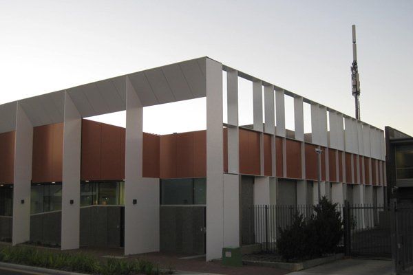 View of armidale courthouse with white columns and orange feature wall 