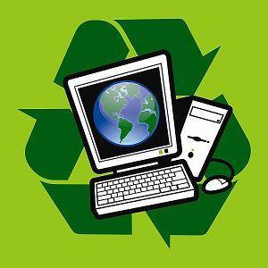 A computer is sitting in front of a green recycling symbol.